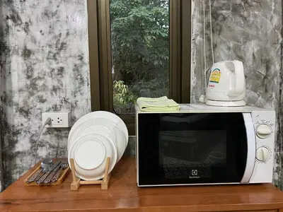 a microwave sitting on top of a wooden table at Green Tree Cottage 2 in Klong Muang Beach