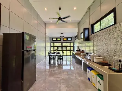a kitchen with a refrigerator and a table in it at Moonlight Cottage in Ban Pa Khlok