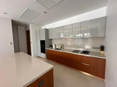 a large kitchen with wooden cabinets and a counter top at Allure Villa in Bangtao in Ban Pak Lak