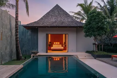 a villa with a swimming pool next to a house at Allure Villa in Bangtao in Ban Pak Lak