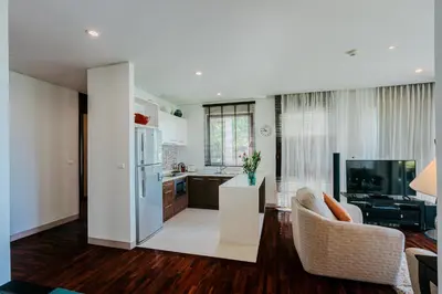 a kitchen and living room with a couch and a refrigerator at Luxury Penthouse Apartment 8C at Kata Gardens in Kata Beach