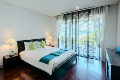 a bedroom with a large bed and a large window at Luxury Penthouse Apartment 8C at Kata Gardens in Kata Beach
