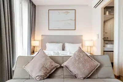 a living room with a couch and a bed at The Proud Rawai Studio in Phuket Town