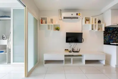 a living room with a white desk and a tv at The Pixels Cape Panwa Condo in Ban Ao Makham
