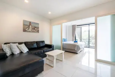 a living room with a couch and a bed at The Pixels Cape Panwa Condo in Ban Ao Makham