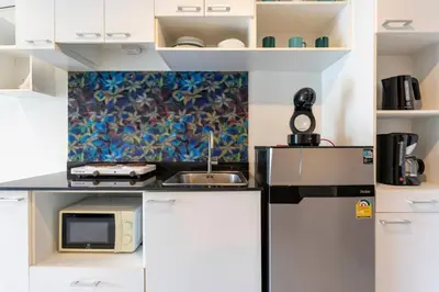 a small kitchen with a sink and a microwave at The Pixels Cape Panwa Condo in Ban Ao Makham