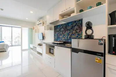 a kitchen with white cabinets and a refrigerator at The Pixels Cape Panwa Condo in Ban Ao Makham