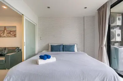 a bedroom with a large bed with blue stuffed animals on it at The Pixels Cape Panwa Condo in Ban Ao Makham