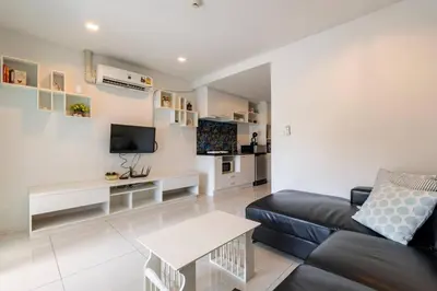 a living room with a couch and a tv at The Pixels Cape Panwa Condo in Ban Ao Makham