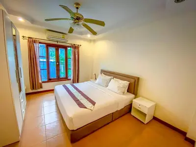 a bedroom with a bed with a ceiling fan at Garden & private pool house in Surin Beach