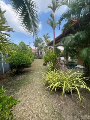 a garden with palm trees and a house at Garden & private pool house in Surin Beach