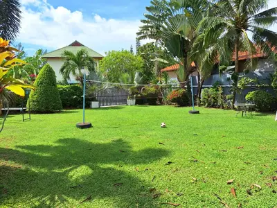 a yard with a volley ball net in the grass at Garden & private pool house in Surin Beach