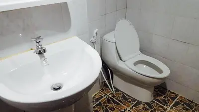 a bathroom with a white toilet and a sink at Lucky Dorm in Phi Phi Don