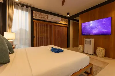 a bedroom with a bed and a tv on a wall at New Ultra Modern Designer Furniture Gym #v62 in Chalong