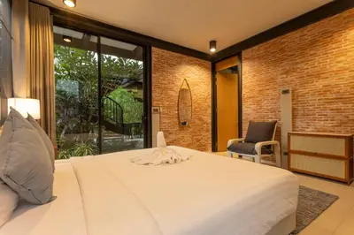 a bedroom with a large white bed and a chair at New Ultra Modern Designer Furniture Gym #v62 in Chalong