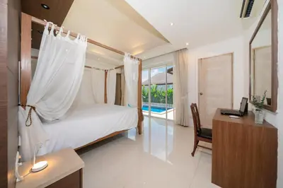 a bedroom with a bed and a desk with a desk at Bangtao Beach Villa with a Long pool 12 meters in Phuket Town