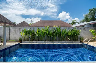 a swimming pool in a backyard with a fence and a retaining wall at Bangtao Beach Villa with a Long pool 12 meters in Phuket Town