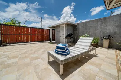 a bench on a patio with a red fence at Bangtao Beach Villa with a Long pool 12 meters in Phuket Town