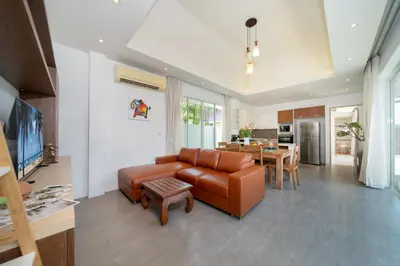 a living room with a leather couch and a table at Bangtao Beach Villa with a Long pool 12 meters in Phuket Town