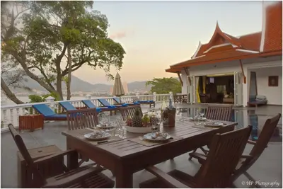 a wooden table and chairs on a patio at Villa REGTUK in Patong Beach