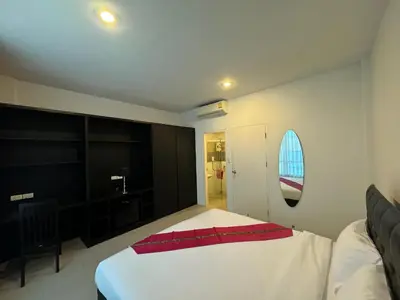 a bedroom with a white bed with a red blanket on it at Vi Stay in Phuket Town