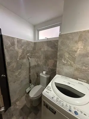 a bathroom with a toilet and a window at Nai Harn Beach Condo (C2) in Rawai Beach
