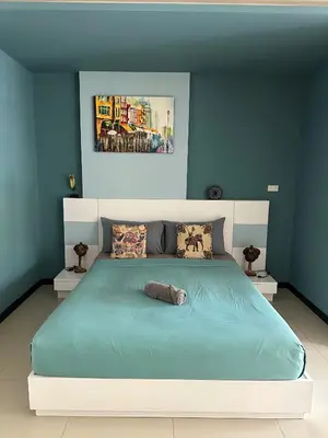 a bedroom with a large bed with blue walls at Nai Harn Beach Condo (C2) in Rawai Beach