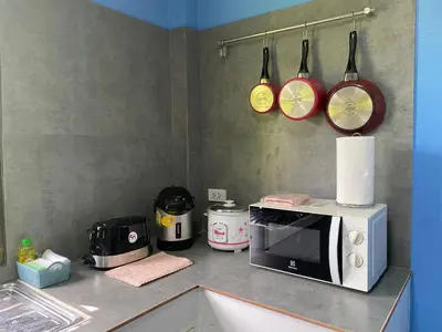 a kitchen counter with a microwave and some pans at Green Tree Cottage3 in Klong Muang Beach