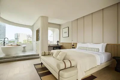 a bedroom with a large bed and a bath tub at Arco Phuket Town in Phuket Town