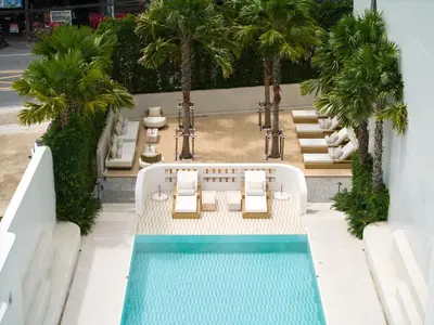 an overhead view of a pool with chairs and palm trees at Arco Phuket Town in Phuket Town