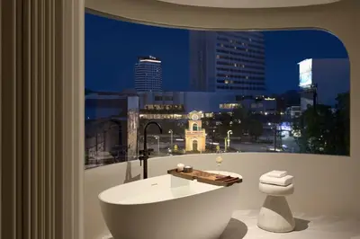a bathroom with a bath tub in front of a window at Arco Phuket Town in Phuket Town