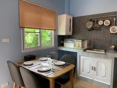a table in a kitchen with chairs and a table and chairsktop at Green Tree Cottage 4 in Klong Muang Beach