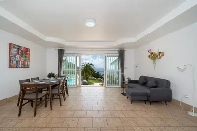 a living room with a table and a couch at Villa Olympus Ocean Vista Kata Beach in Kata Beach