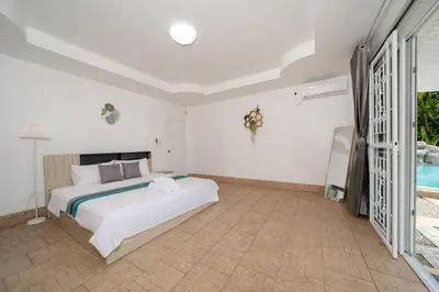 a bedroom with a bed and a pool at Villa Olympus Ocean Vista Kata Beach in Kata Beach