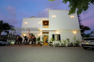 two people standing in front of a white house at Puean Chang Resort Phuket in Thalang