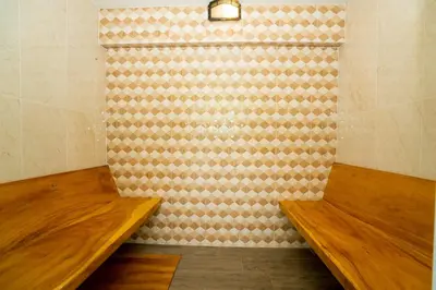 a room with two wooden benches and a wall at Puean Chang Resort Phuket in Thalang