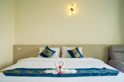 a stuffed animal is sitting on a bed at Puean Chang Resort Phuket in Thalang
