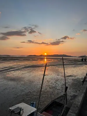 a boat on the beach with the sunset in the background at Ban Tha Ton Do Koh Yao noi in Ko Yao Noi