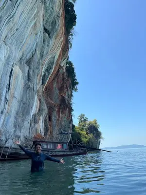 a person in the water near a rock formation at Ban Tha Ton Do Koh Yao noi in Ko Yao Noi
