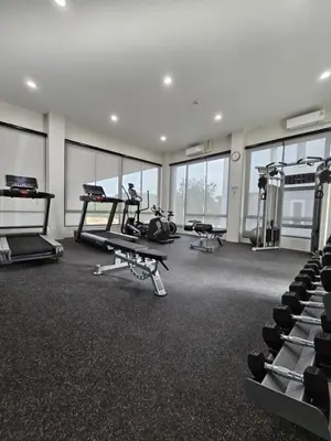 a gym with treadmills and machines in a room with windows at The Title Halo 1 Jupiter in Nai Yang Beach