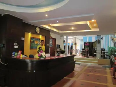 a man standing at a bar in a restaurant at MT Hotel Patong in Patong Beach