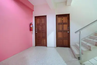 a hallway with two doors and a pink wall at OYO 1148 Aonang Andaman Resort in Ao Nang Beach