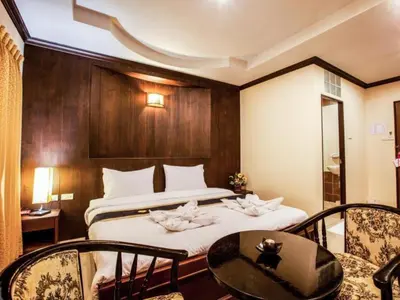 a hotel room with a bed and a table and chairs at Triple Rund Place Hotel in Patong Beach