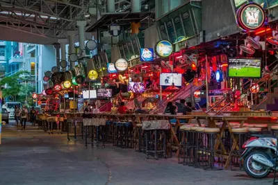 a restaurant with tables and chairs and lights at Triple Rund Place Hotel in Patong Beach