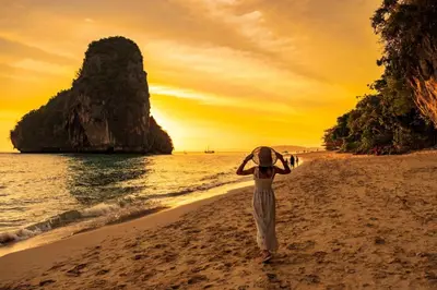 a person walking on the beach at sunset at OYO 681 Paradise Hotel in Ao Nang Beach