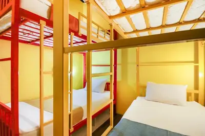 a room with two bunk beds in a dorm room at OYO 1074 Fin Hostel in Kata Beach