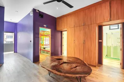 a coffee table in a room with purple walls at OYO 1074 Fin Hostel in Kata Beach