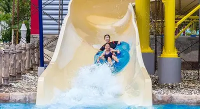 a man and a woman riding a water slide at OYO 1075 The View at Naiyang in Nai Yang Beach