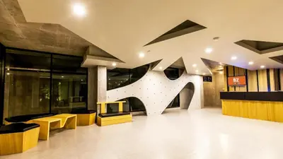 a large lobby with yellow and black furniture in a building at B2 Phuket Boutique & Budget Hotel in Ban Sam Kong
