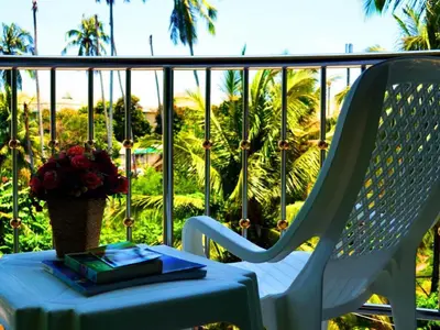 a table and a chair on a balcony with a vase of flowers at Sairougn Seaview Hotel in Ban Ko Kwang